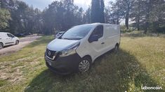 a white van parked in the middle of a field next to some trees and grass