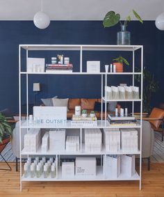 the shelves are full of boxes and bottles on display in front of a blue wall