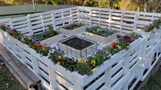 an outdoor garden area made out of wooden pallets with plants growing in the center