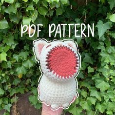 a hand holding up a white and red crocheted hat with the words pop pattern on it