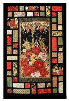 a quilted wall hanging with flowers and leaves on the front, along with black background