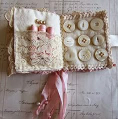 two pieces of fabric with buttons and lace on them sitting on top of a table