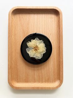 a wooden tray with a flower on it