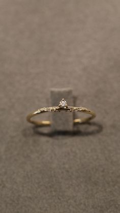 a gold ring with a cross on the side and a diamond in the middle is shown