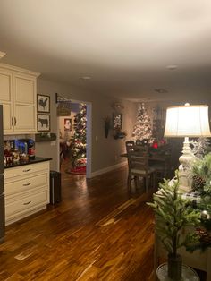 a living room filled with furniture and christmas decorations on top of a hard wood floor