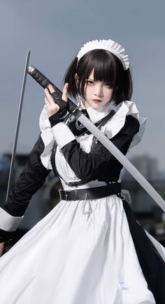 a woman dressed in black and white holding two swords