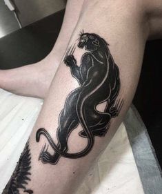 a black and white tattoo on the leg of a man