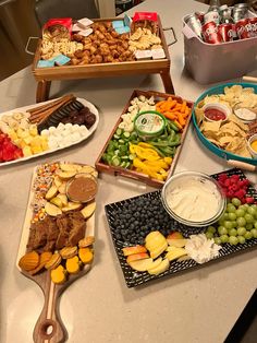 several trays filled with different types of food on top of a white countertop