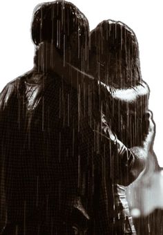 two people standing in the rain with their heads touching each other's foreheads