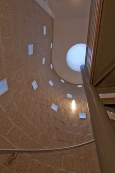 the inside of a building with many square tiles on the walls and floor, as well as a round window