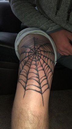 a man with a spider web tattoo on his leg