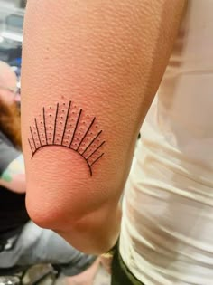 a person with a tattoo on their arm that has spikes in the middle of it