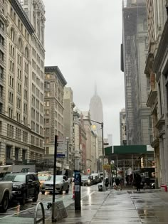 an empty city street with cars parked on the side