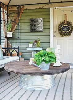 an outdoor patio with furniture and plants on the table, in front of a door