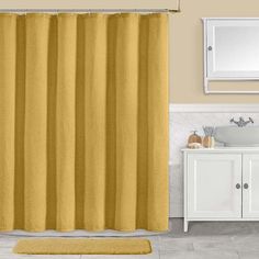 a bathroom with a yellow shower curtain next to a white sink and mirror on the wall