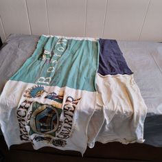 three different colored shirts laying on top of a bed next to each other in front of a white wall