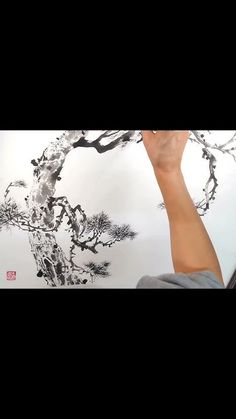 a man is painting a wall with black and white ink