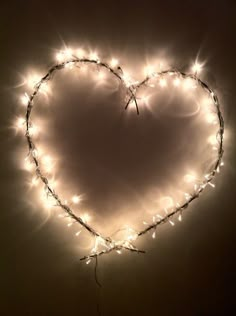 a heart made out of fairy lights on a white wall in the shape of a heart