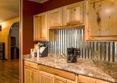 a kitchen with wooden cabinets and granite counter tops, along with a coffee maker in the corner