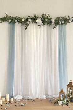 a white and blue wedding backdrop with flowers