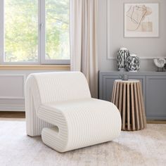 a white chair sitting in front of a window