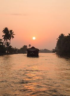 the sun is setting over the water and some palm trees are in the foreground