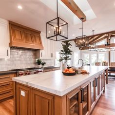 a large kitchen with wooden cabinets and white marble counter tops, along with an island in the center