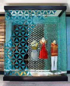 two mannequins are standing in front of a blue wall with geometric designs