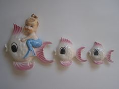 three little figurines sitting on top of each other in the shape of fish