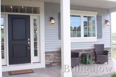 the front porch of a house with two chairs on it