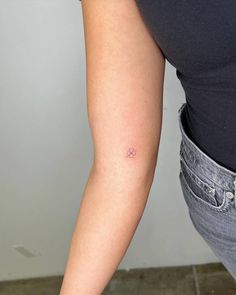 a woman's arm with a small tattoo on the left side of her arm