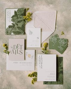 the wedding stationery is laid out on top of each other, with yellow flowers and greenery