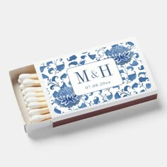 matches with blue and white floral design on the top are in a matchbox, which reads m & h