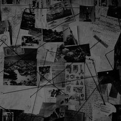 black and white photograph of many different papers on the wall with pins stuck to them