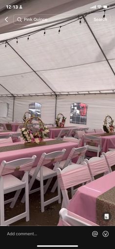 the inside of a tent with pink tables and chairs