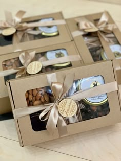 four boxes filled with assorted cookies and candies on top of a wooden table