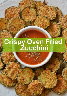 crispy oven fried zucchini on a plate with dipping sauce in the middle