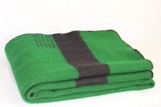 two green and black towels folded on top of each other in front of a white background