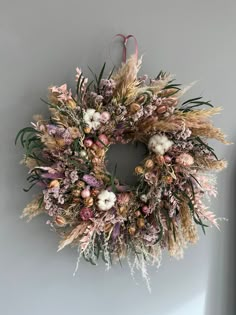 a wreath hanging on the wall with dried flowers