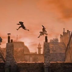 some people are jumping in the air over rooftops and buildings at sunset or dawn