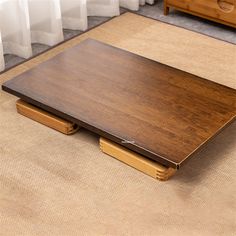 a wooden table sitting on top of a rug