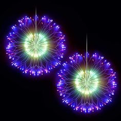 two fireworks are lit up in the night sky with colorful lights on them and circular shapes