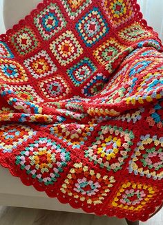 a red crocheted blanket sitting on top of a window sill