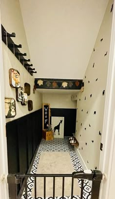 the hallway is decorated with black and white wallpaper, patterned flooring, and metal railings