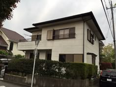 a car parked in front of a two story house on the side of a street