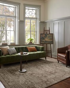 a living room filled with furniture and large windows