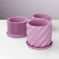 three purple vases sitting next to each other on a table