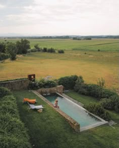 an aerial view of a pool in the middle of a field