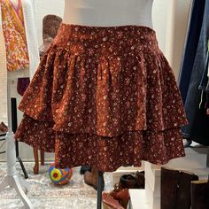 This Adorable Skirt Features Two Layers Of Tiered, Corduroy Floral, And Elastic Smocking In The Back For A Great Flexible Fit Fall Fitted Tiered Skort, Fitted Tiered Mini Skirt For Fall, Fitted Tiered Skort For Fall, Floral Print Tiered Skirt For Fall, Casual Ruffled Skirt For Fall, Tiered Floral Print Skirt For Fall, Fall Floral Print Tiered Skirt, Trendy Tiered Skirt For Fall, Non-stretch Cotton Skirt With Floral Print