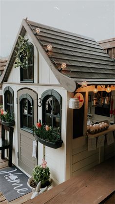 a doll house with flowers and lights on the roof